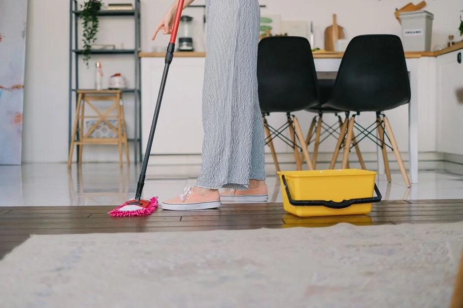 Cleaner using a vacuum in a stylish indoor setting, showcasing cleaning equipment and techniques.
